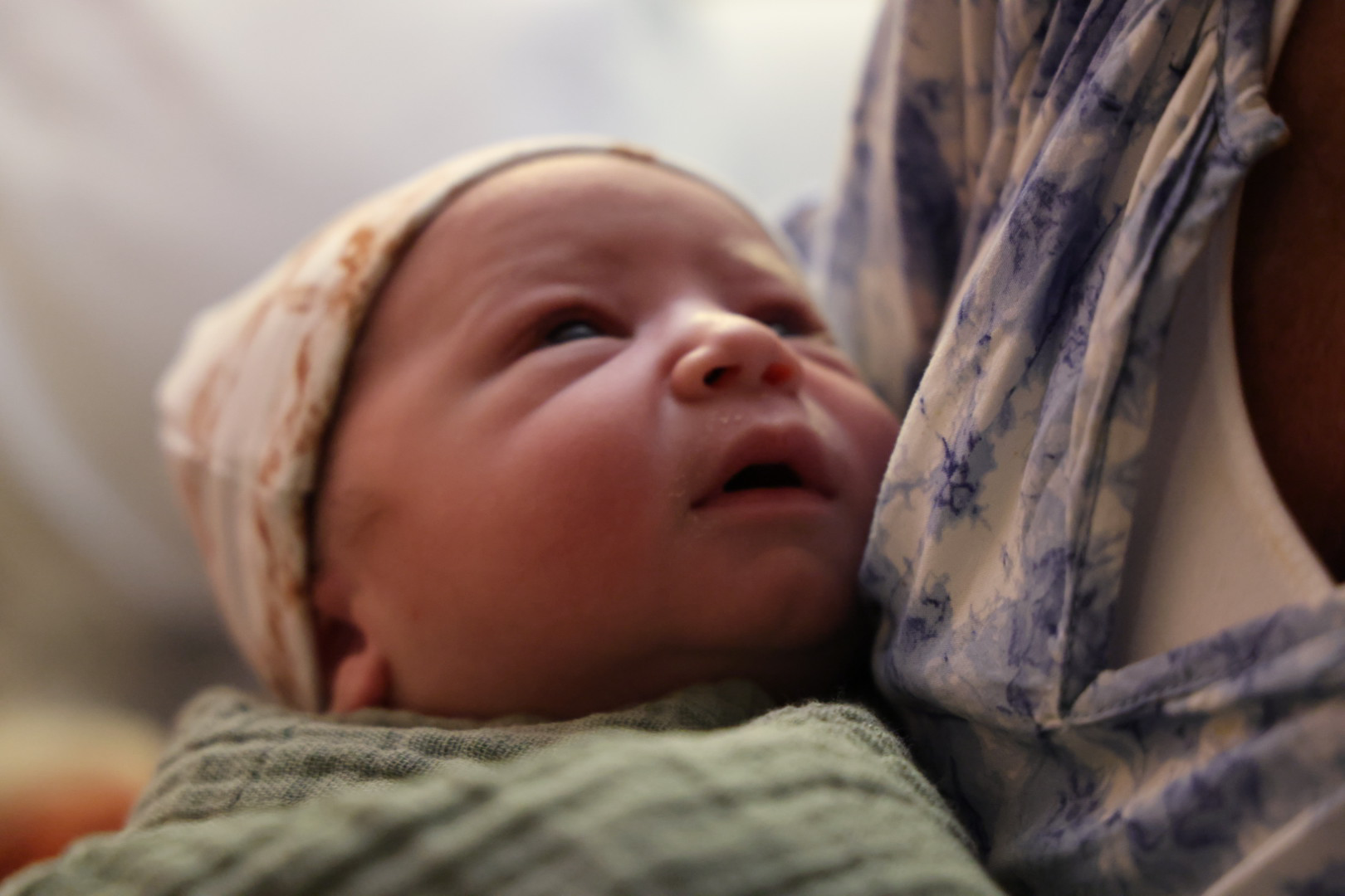 Waylon awake in his mother's arms, looking up