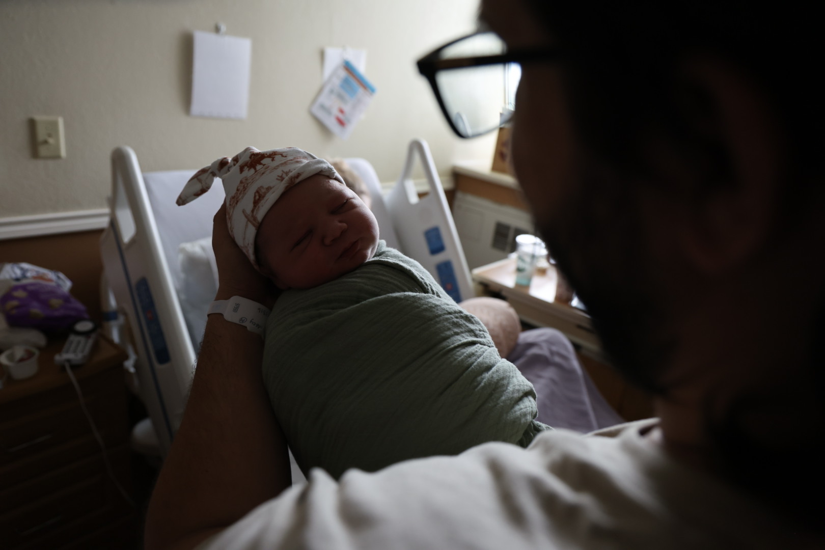 Father holding newborn Waylon against his chest in the hospital room