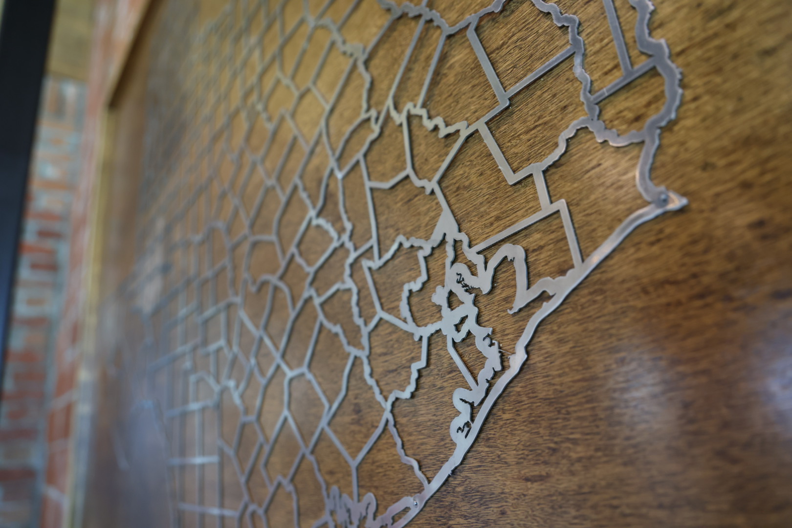 Metal cutout map of the Texas coast mounted on wood