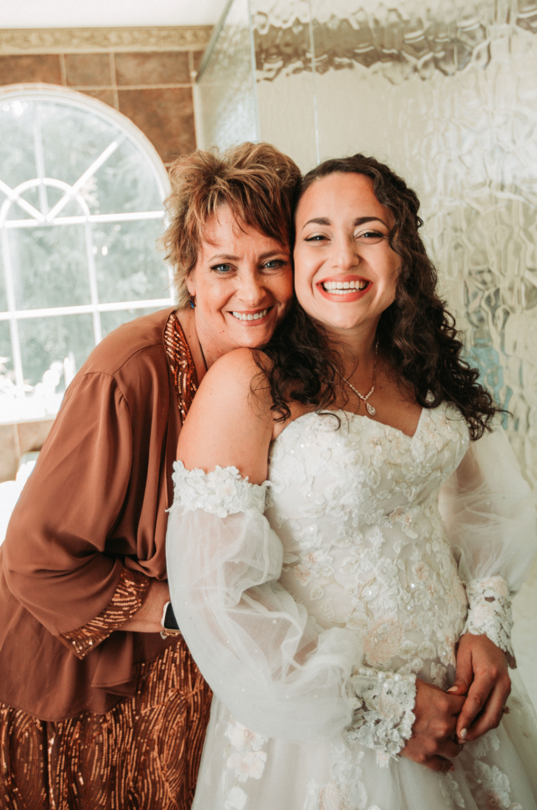 Jessie and an older woman smiling together in the bridal suite
