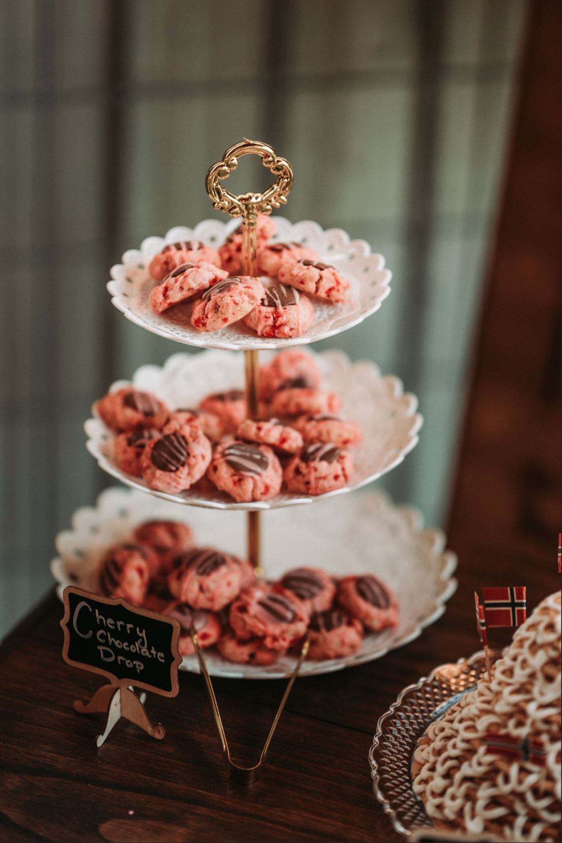 Three-tier stand of cherry chocolate drop cookies with a chalkboard sign
