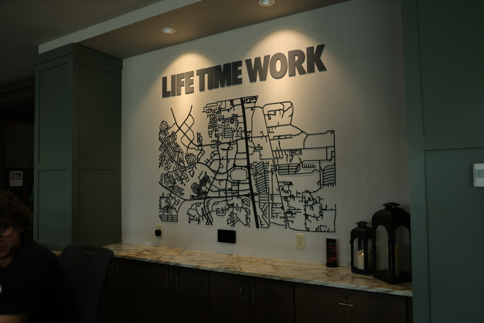 LIFE TIME WORK signage and city map installation above the front desk