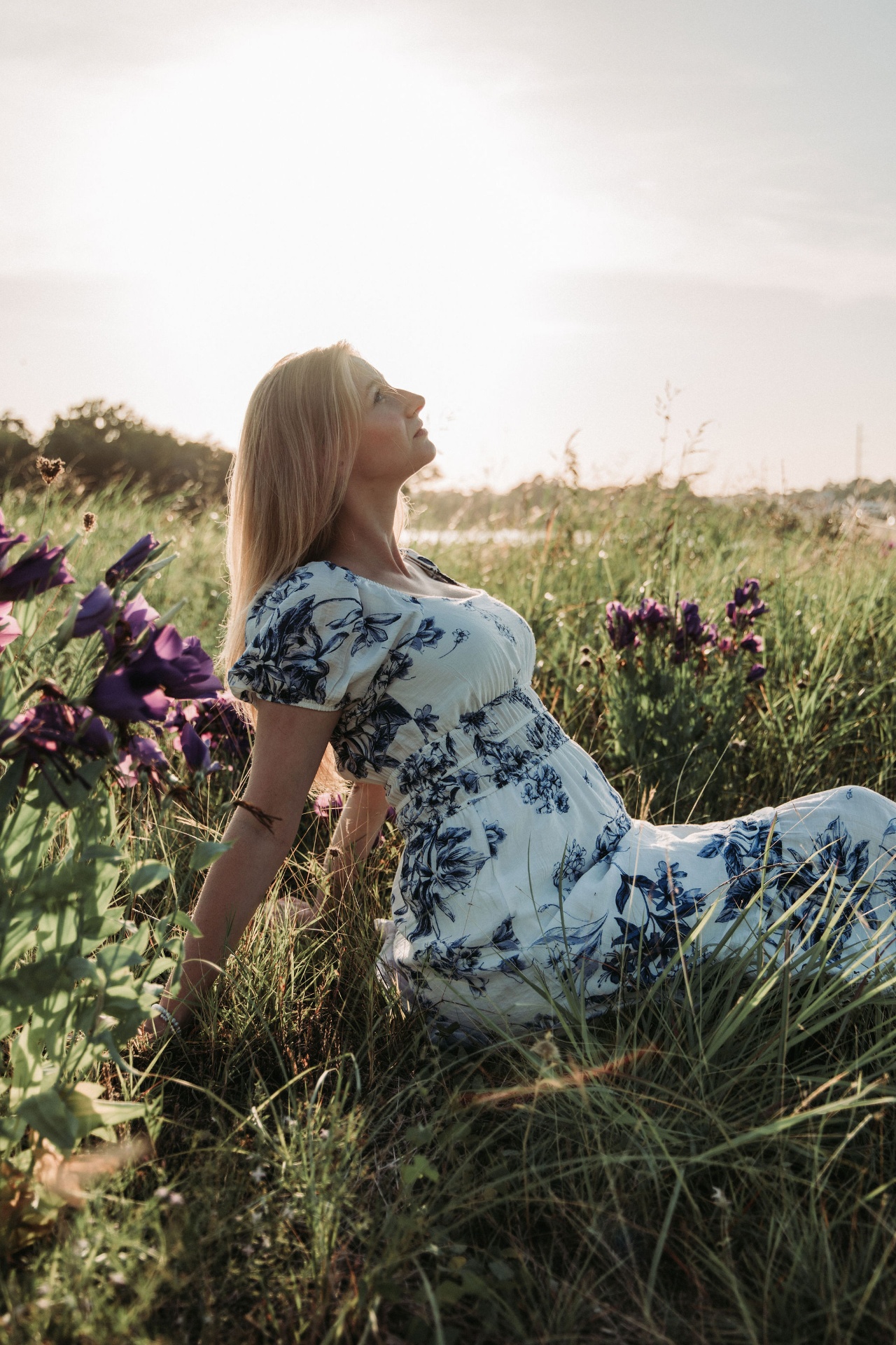 Naomi in a floral dress catching the last sun in a meadow